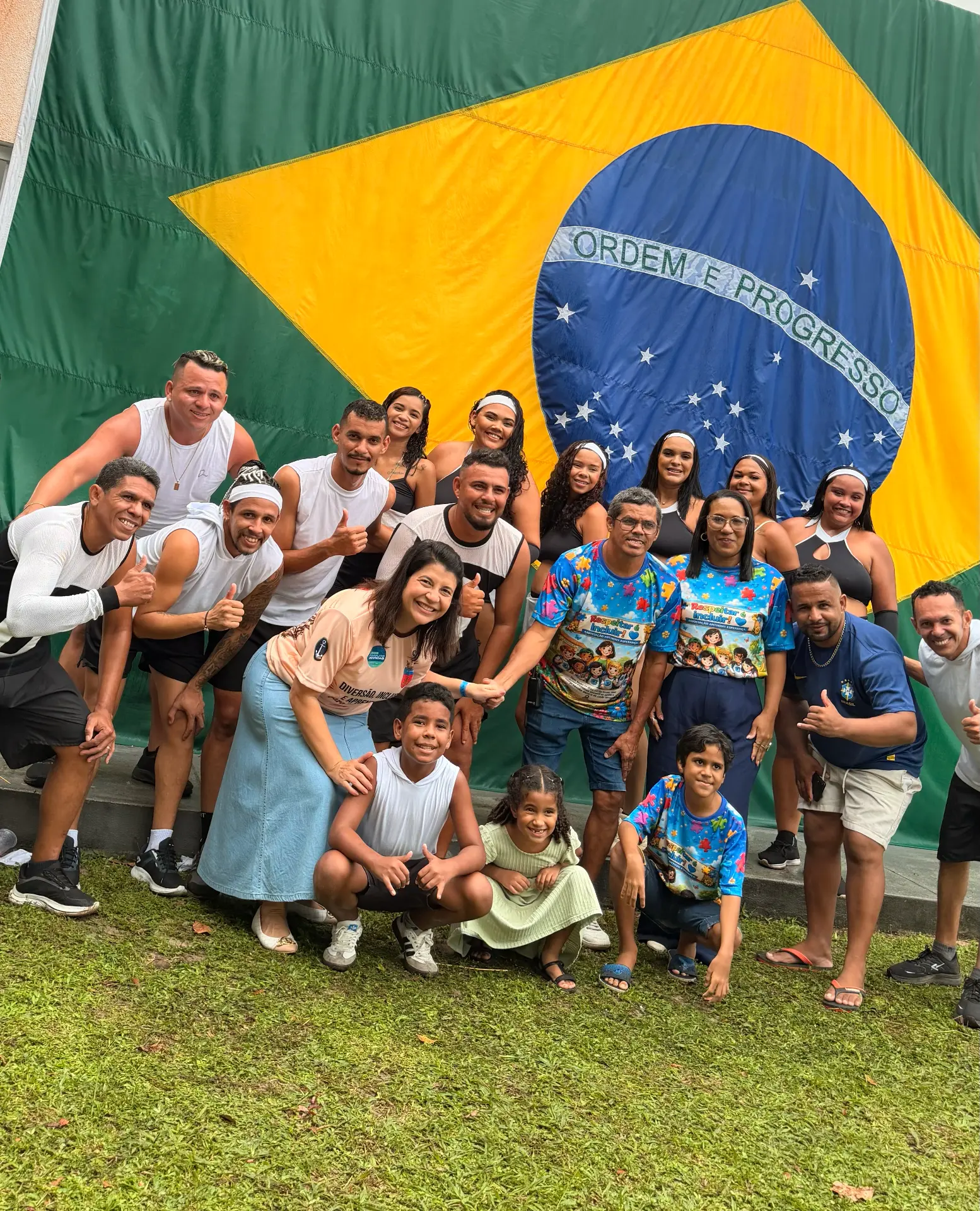 Carla Dickson com famílias atípicas diante da bandeira do Brasil