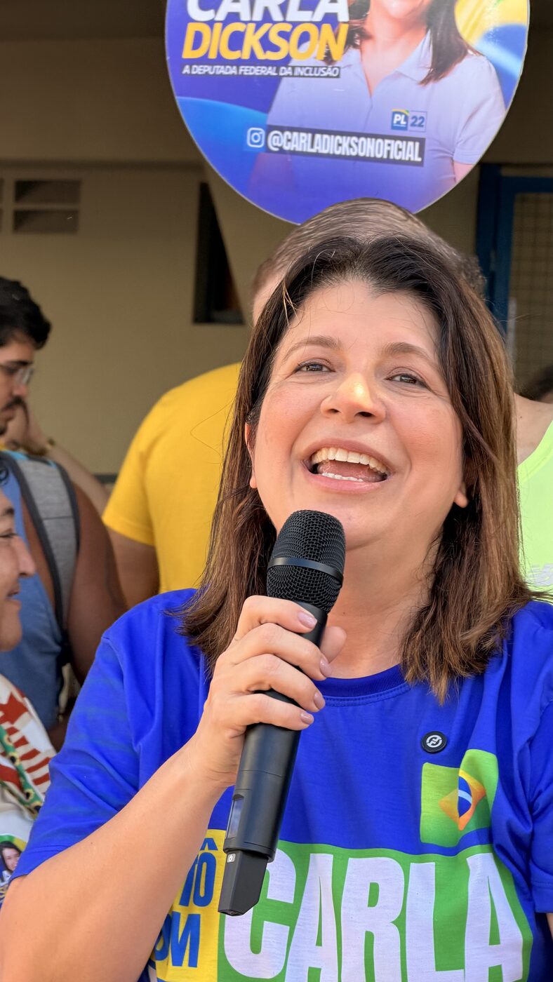 Carla Dickson discursando ao microfone em evento com apoiadores